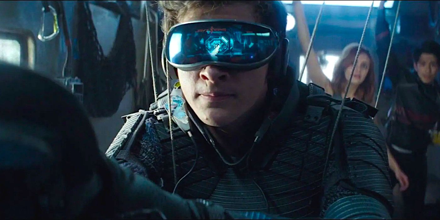 Tye Sheridan plays a video game wearing a VR headset while Olivia Cooke and Win Morisaki look on with rapt attention in a dramatic scene from Ready Player One