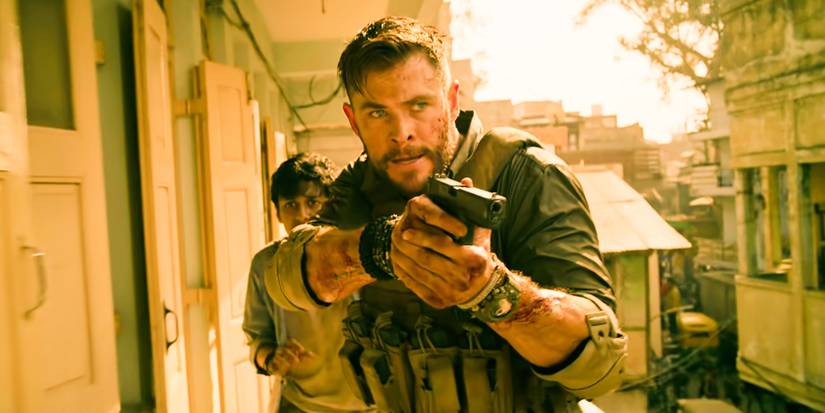 Tyler Rake charging in front of Ovi with his gun drawn in Extraction