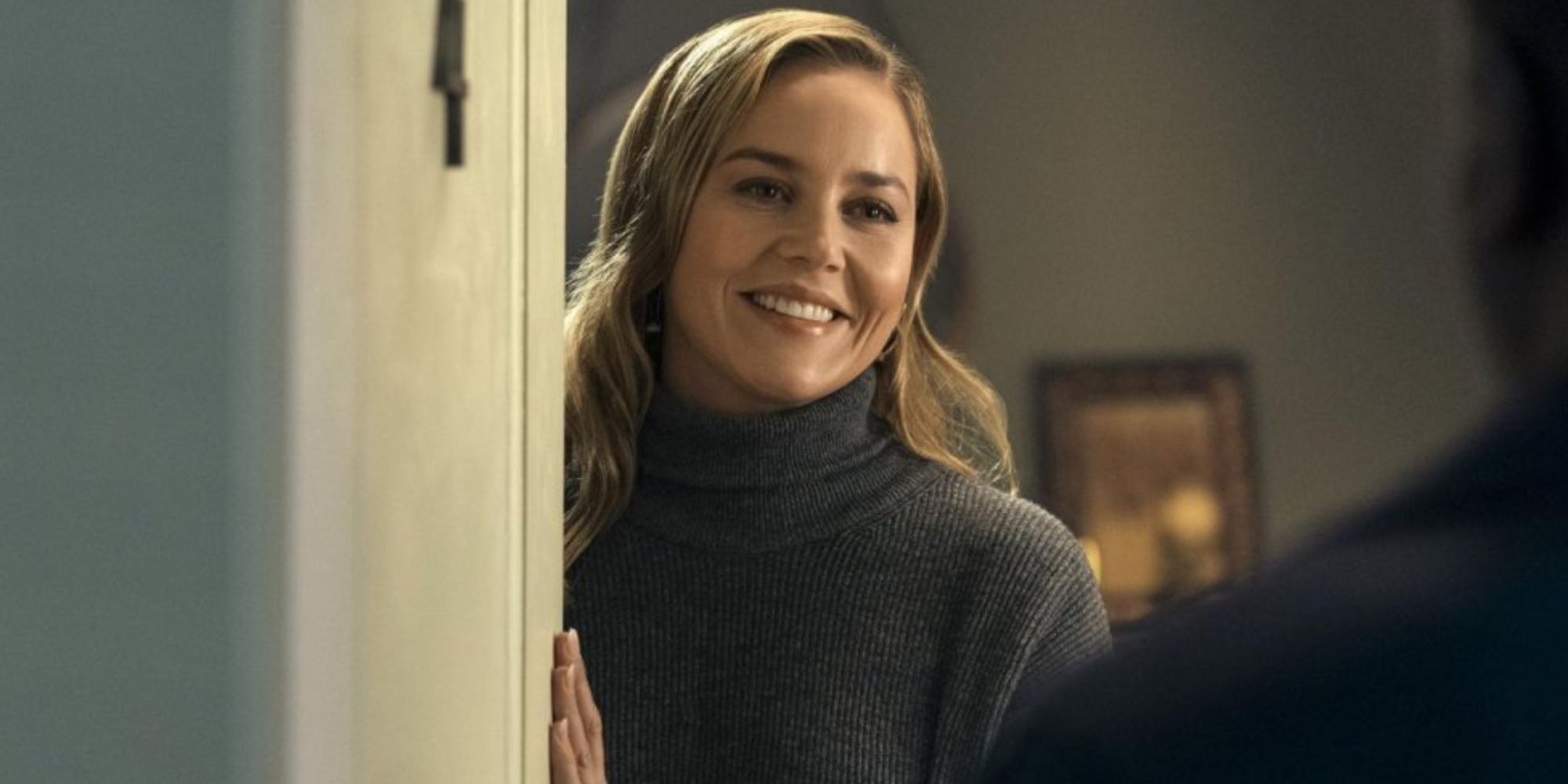 Abbie Cornish smiling and opening the door as Cathy Mueller in Tom Clancy's Jack Ryan