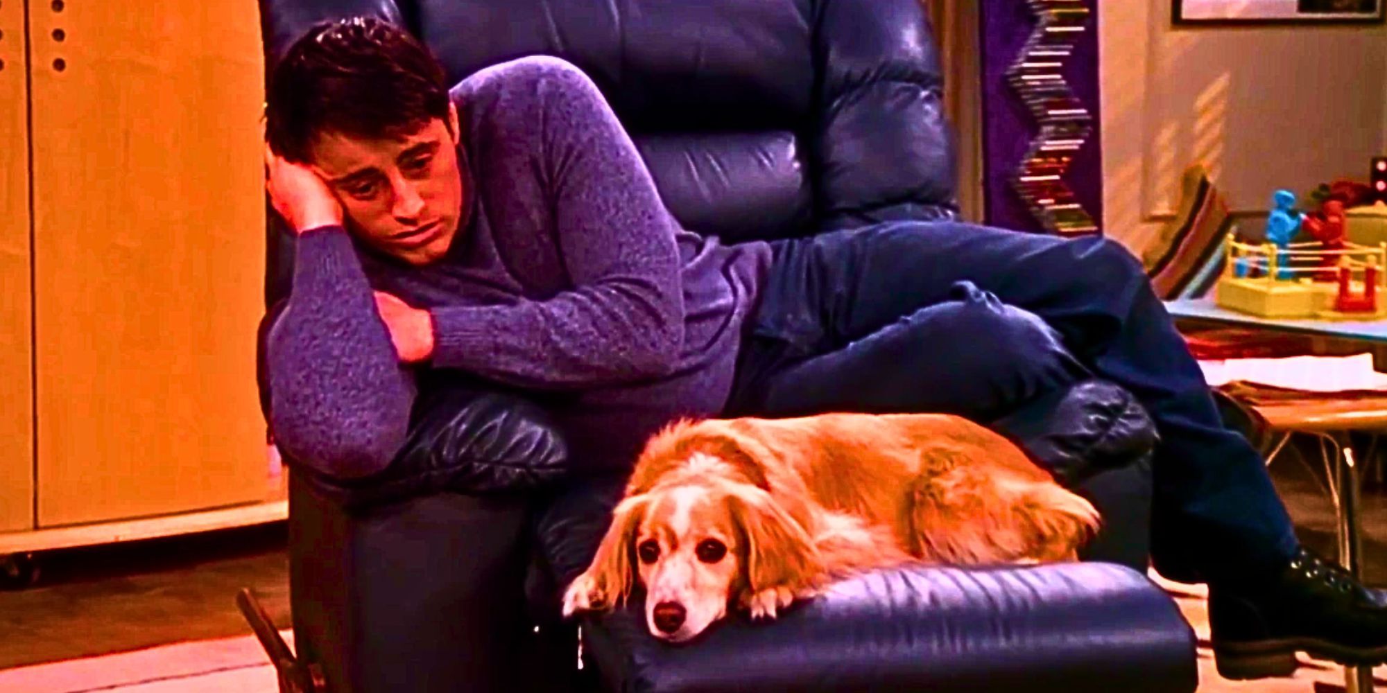 Matt LeBlanc as Joey Tribbiani in Friends looking sad on a chair with an equally sad dog