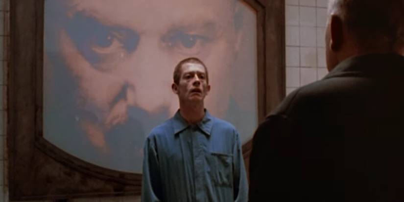 John Hurt as Winston Smith with Big Brother watching on screen behind him in Nineteen Eighty-Four 1984