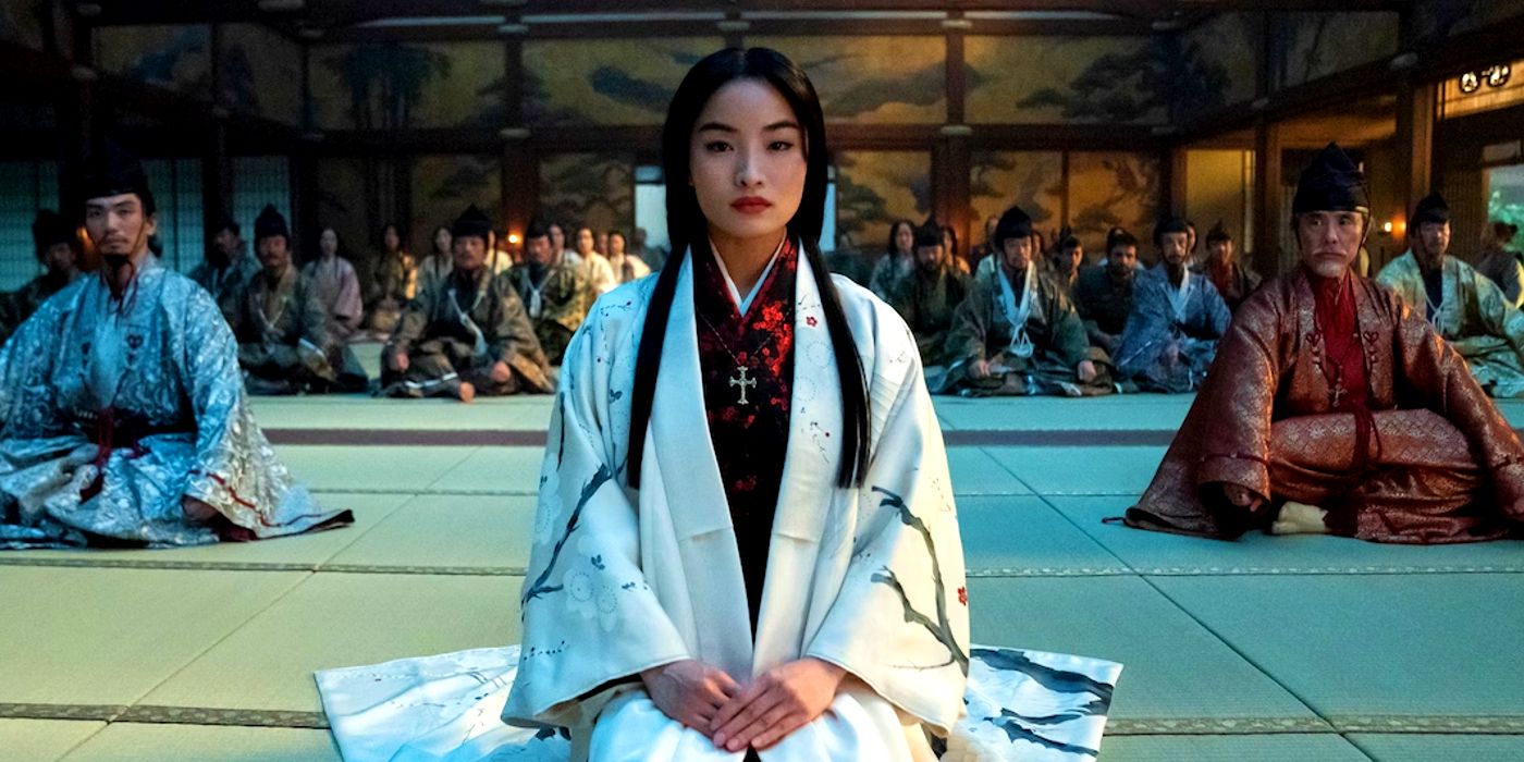 Anna Sawai as Lady Mariko wearing a white and sitting in a room with everyone behind her in Shogun