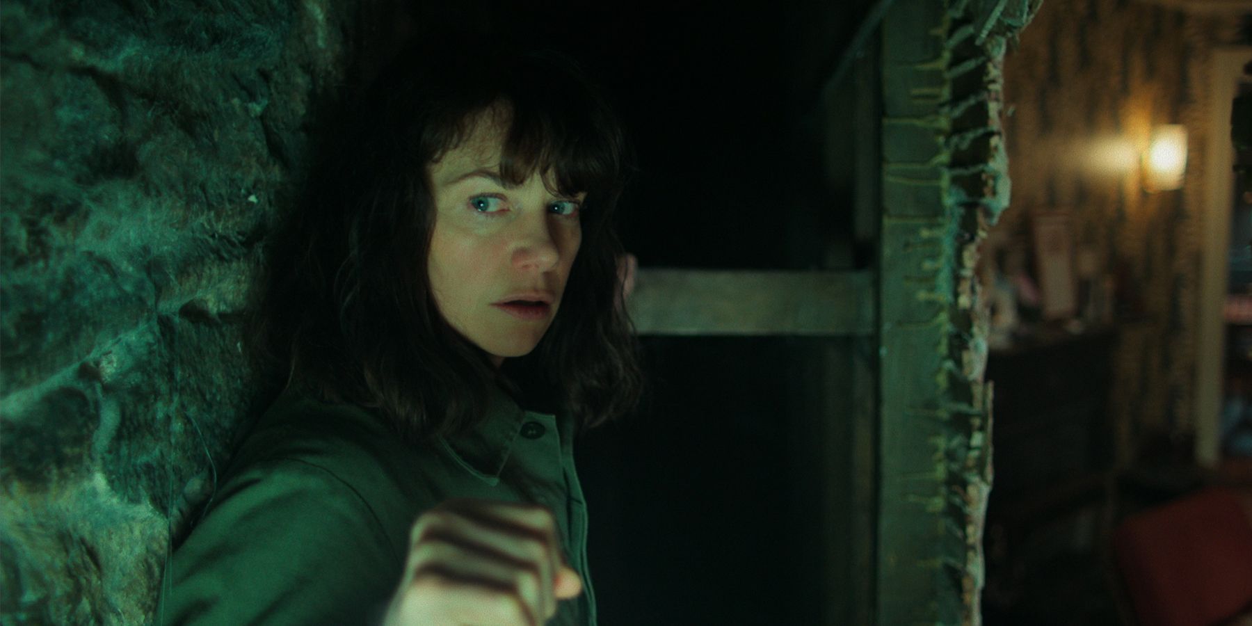 Lorna searching behind the wall in The Woman in the Wall.