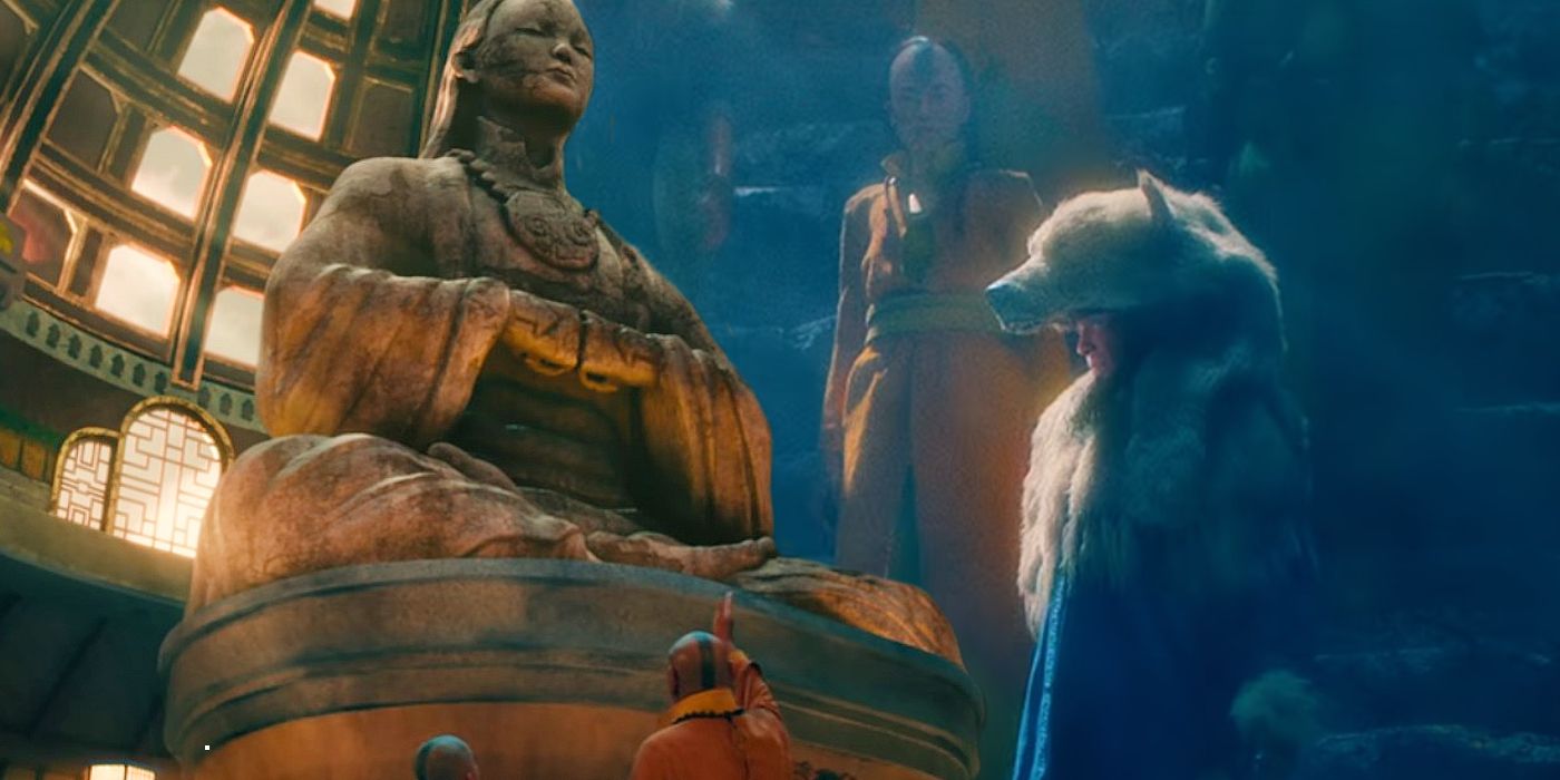 Gyatso apontando para a estátua de Yangchen ao lado dela nos degraus como um Avatar em The Last Airbender da Netflix