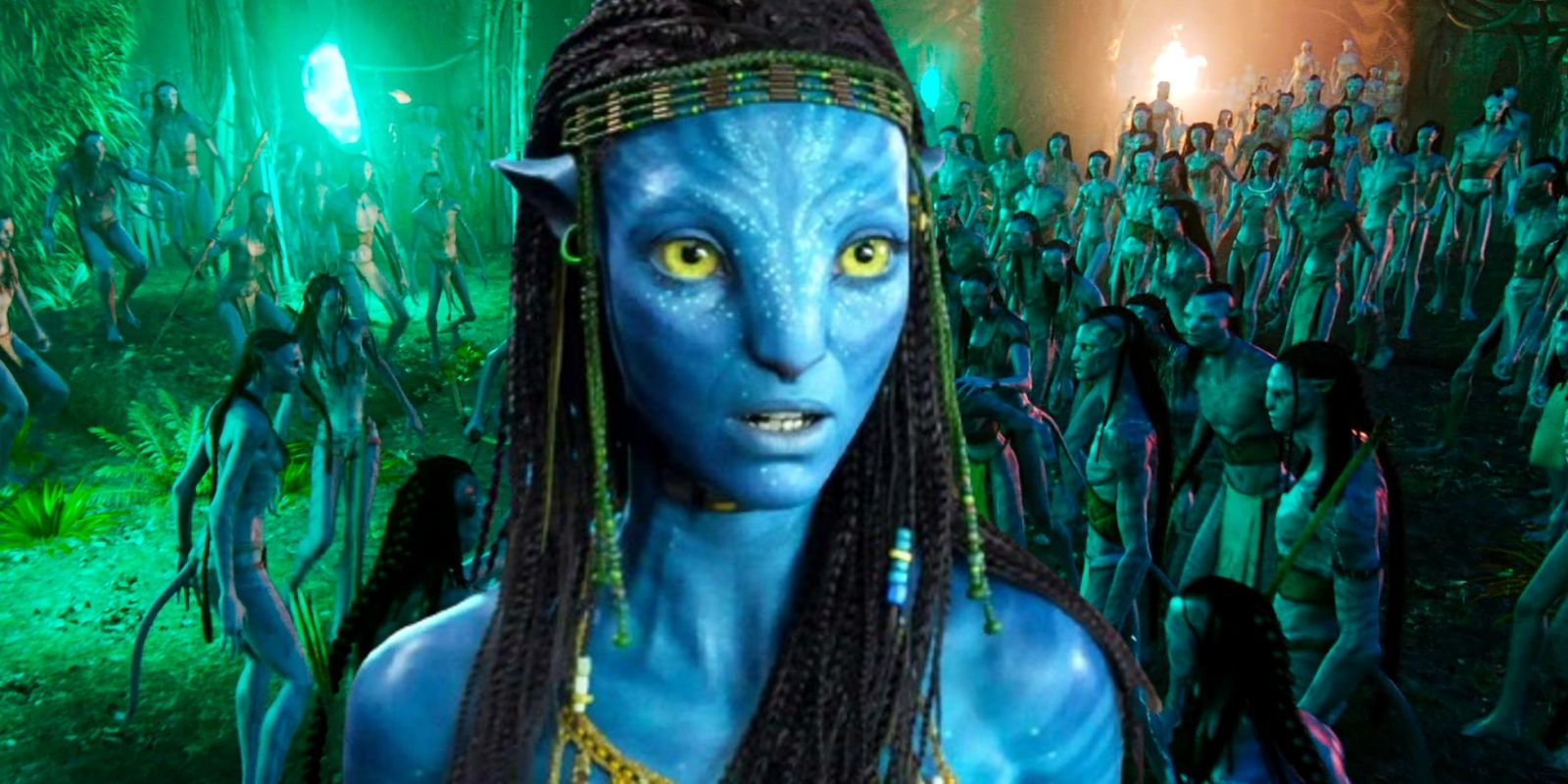 Zoe Saldaña as Neytiri looking surprised in front of a Na'vi clan in Avatar