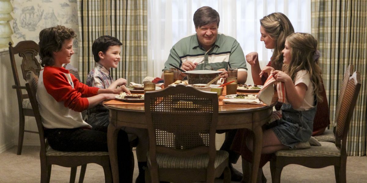 The Cooper family laughing at the dinner table in Young Sheldon