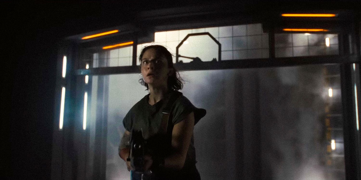 Cailee Spaeny holds a gun while walking through a foggy corridor in Alien: Romulus