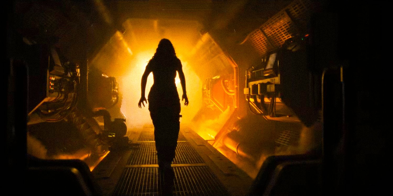 Cailee Spaeny is backlit as she walks down a shadowy corridor in Alien: Romulus