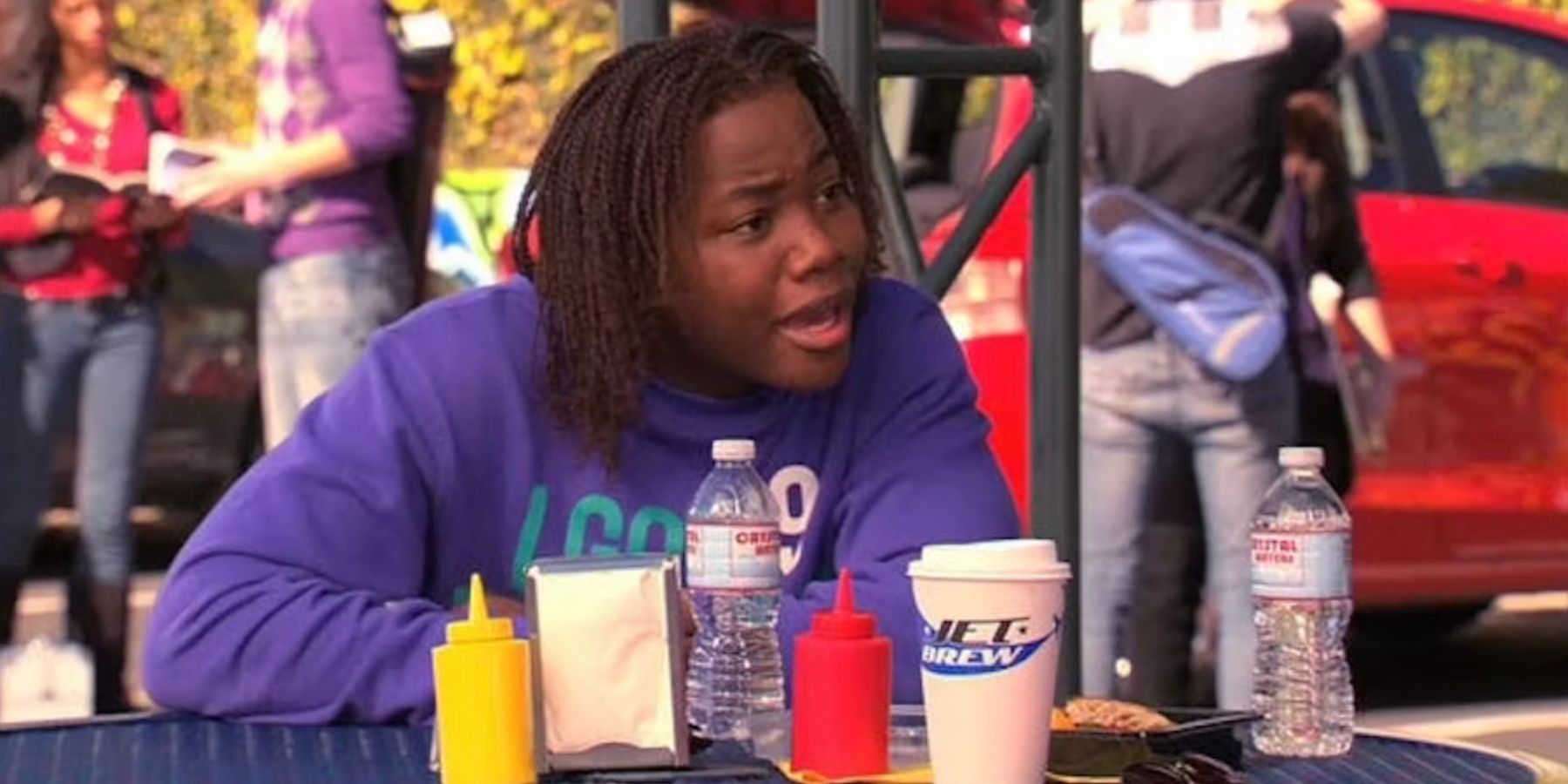 Andre at a lunch table with short condiment bottles in front of him in Victorious