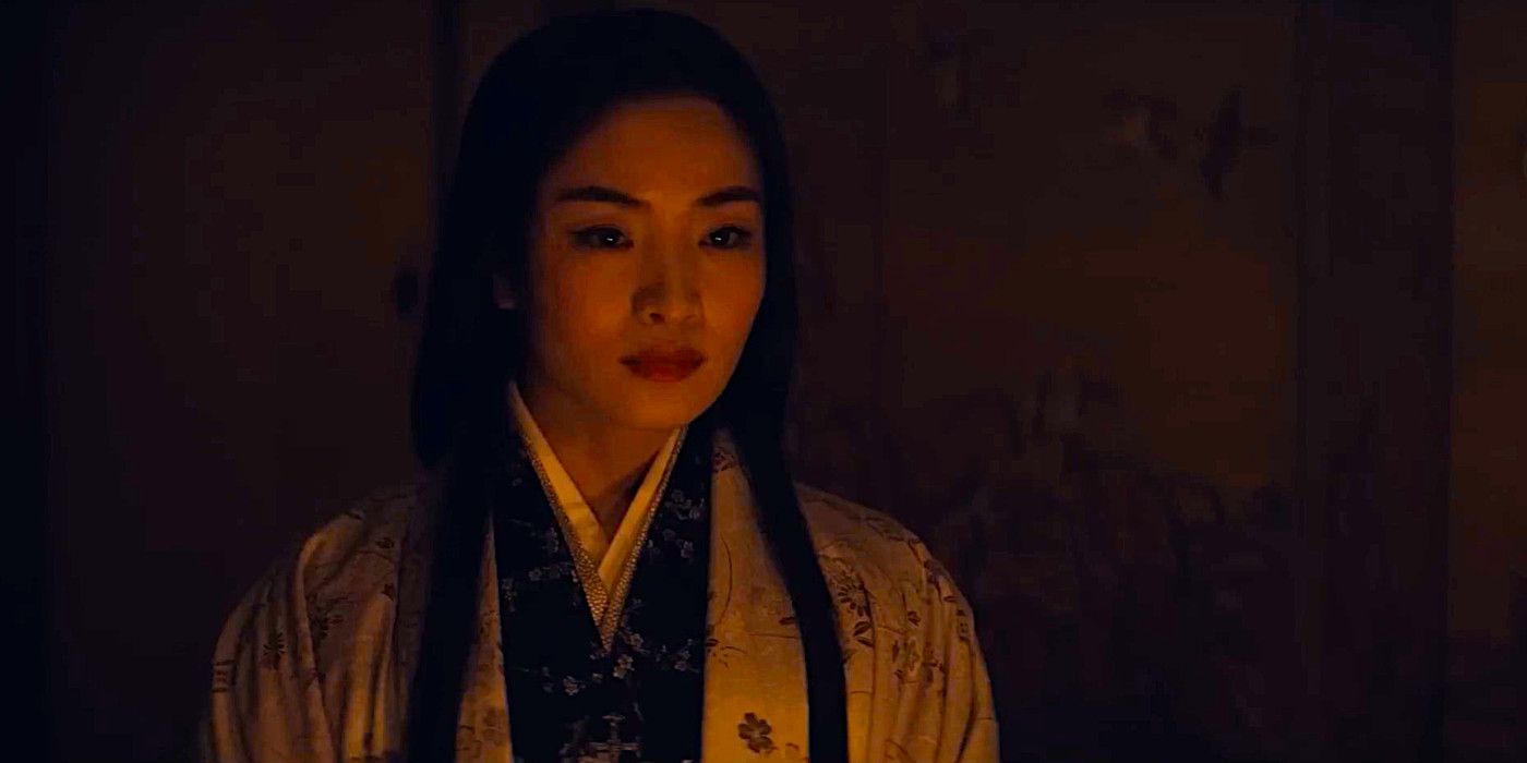 Anna Sawai sits in moody lighting looking impassive in a scene from Shogun