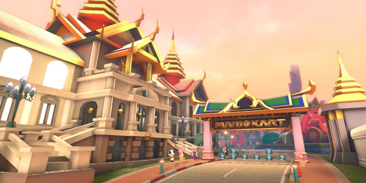 Bangkok Rush Mario Kart track showing large white and gold buildings and the start/finish line with item boxes.