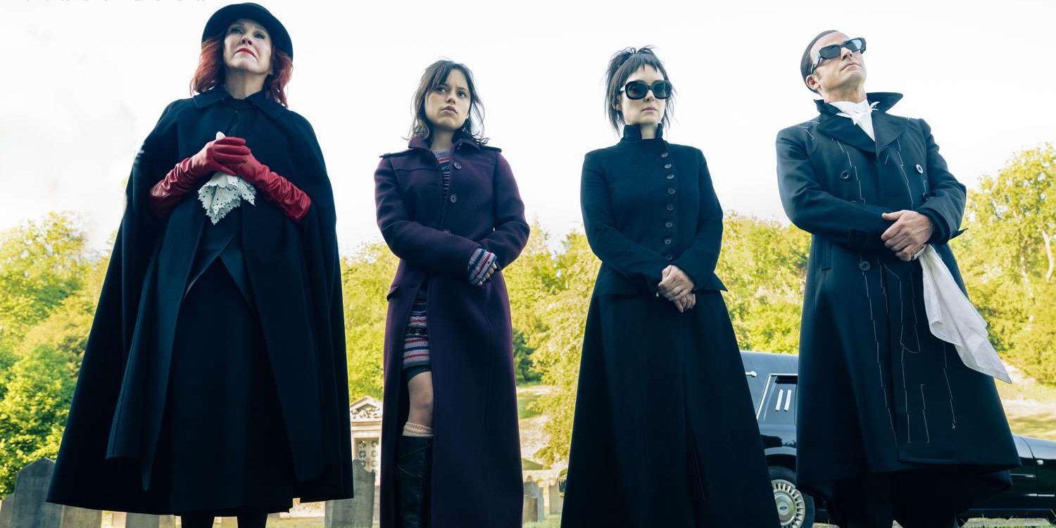 Delia (O'Hara), Astrid (Ortega), Lydia (Ryder), and Rory (Theroux) at a funeral in Beetlejuice 2