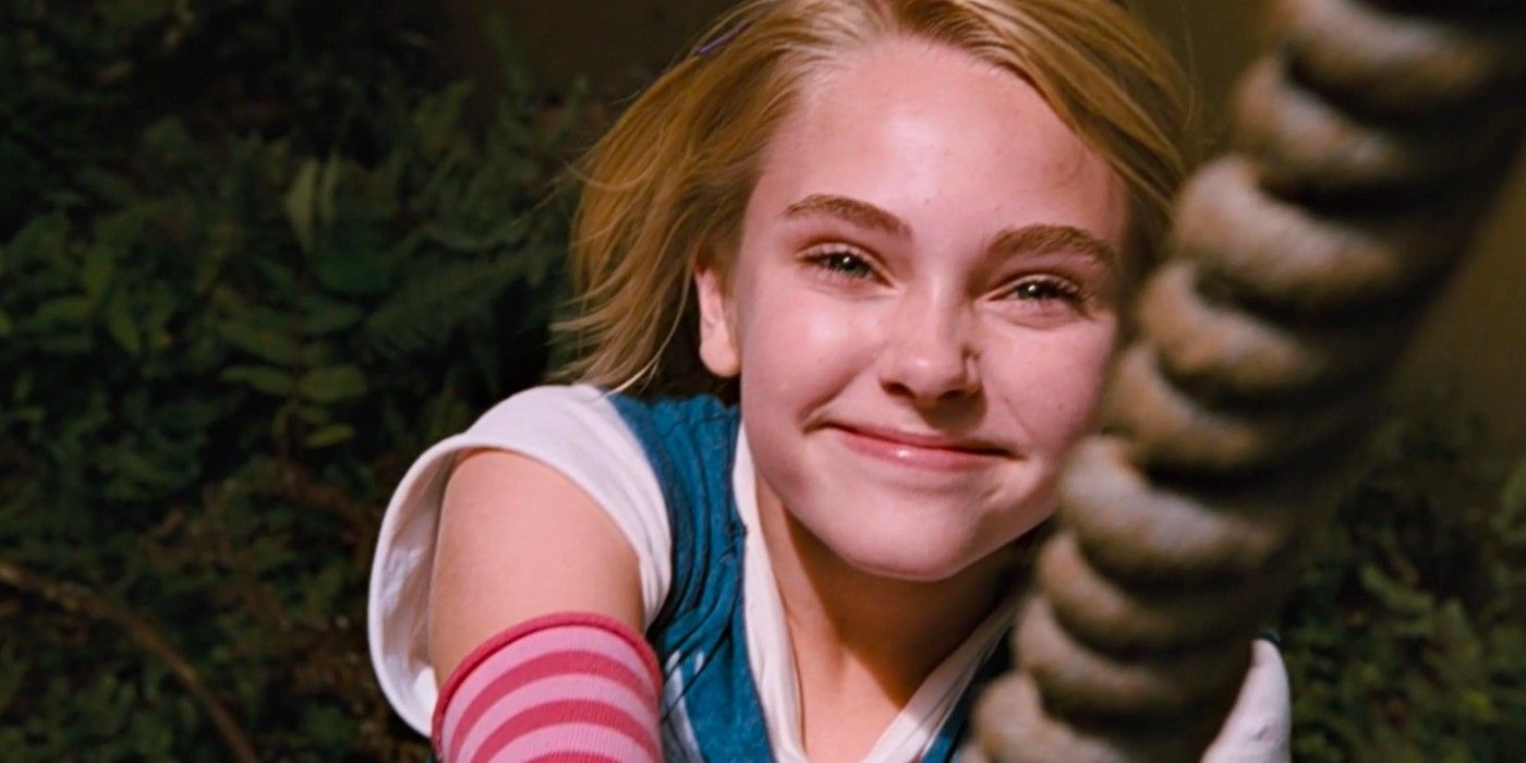 AnnaSophia Robb as Leslie smiling and clinging on to the swing rope in Bridge To Terabithia