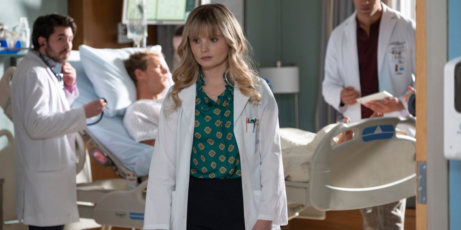 The Good Doctor's Charlie stands in front of a hospital bed where other doctors are working. She is in the center of the photo close to the camera and the action is further away behind her