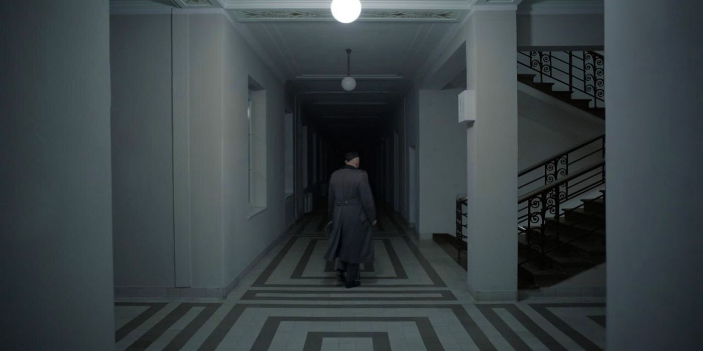 Christian Friedel as Rudolph Hoss walking down a staircase in The Zone of Interest's ending