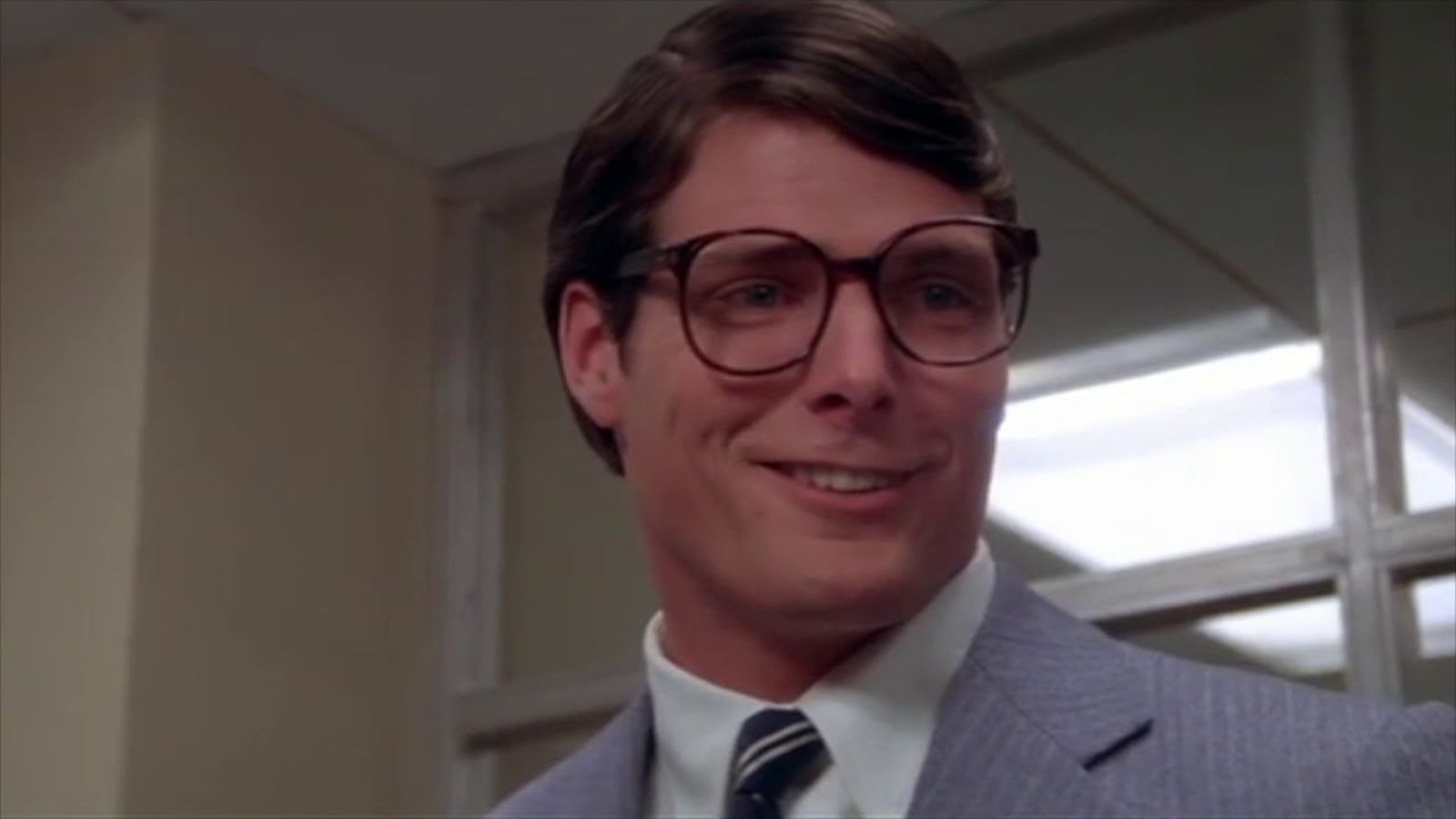 Christopher Reeve as Clark Kent, smiling in a suit in Superman