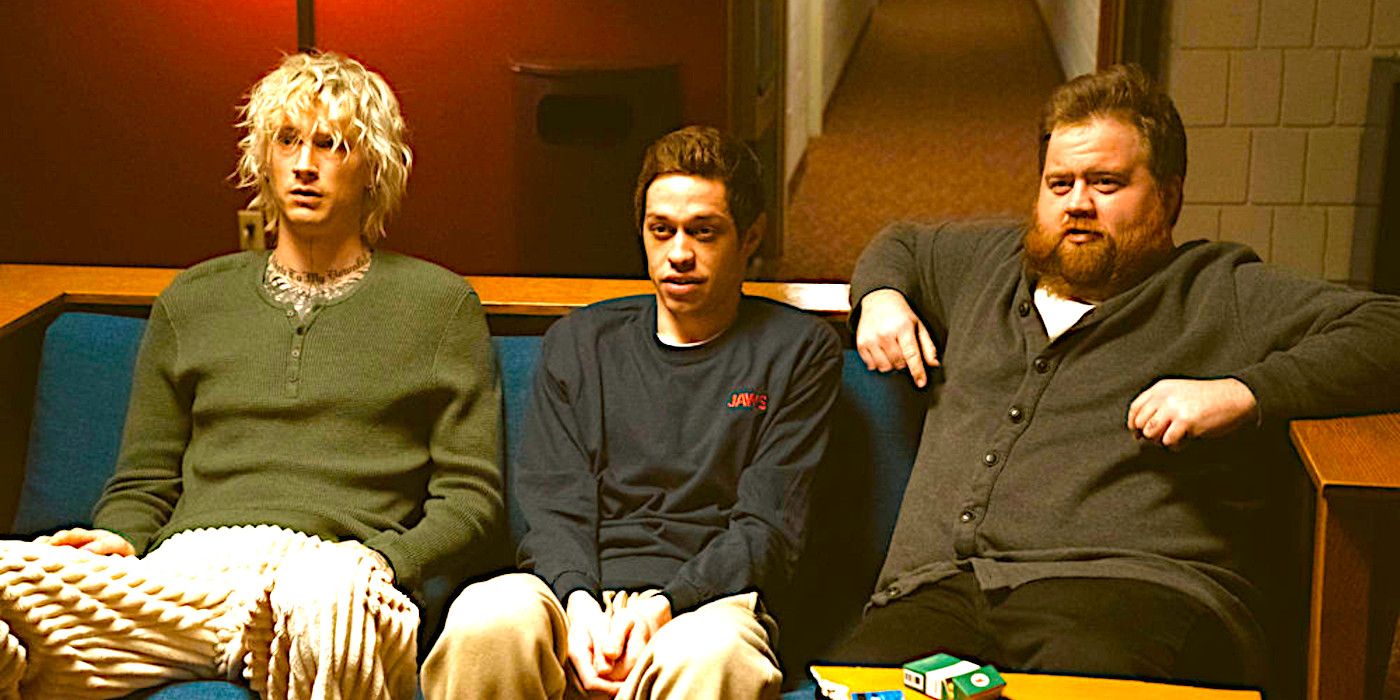 Colson Baker, Pete Davison and Paul Walter Hauser sitting together on a couch looking intimidated in a scene from Bupkis