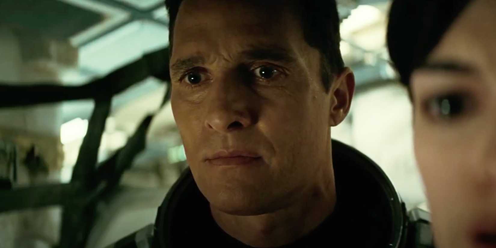 Cooper (Matthew McConaughey) standing behind Brand (Anne Hathaway) in Interstellar