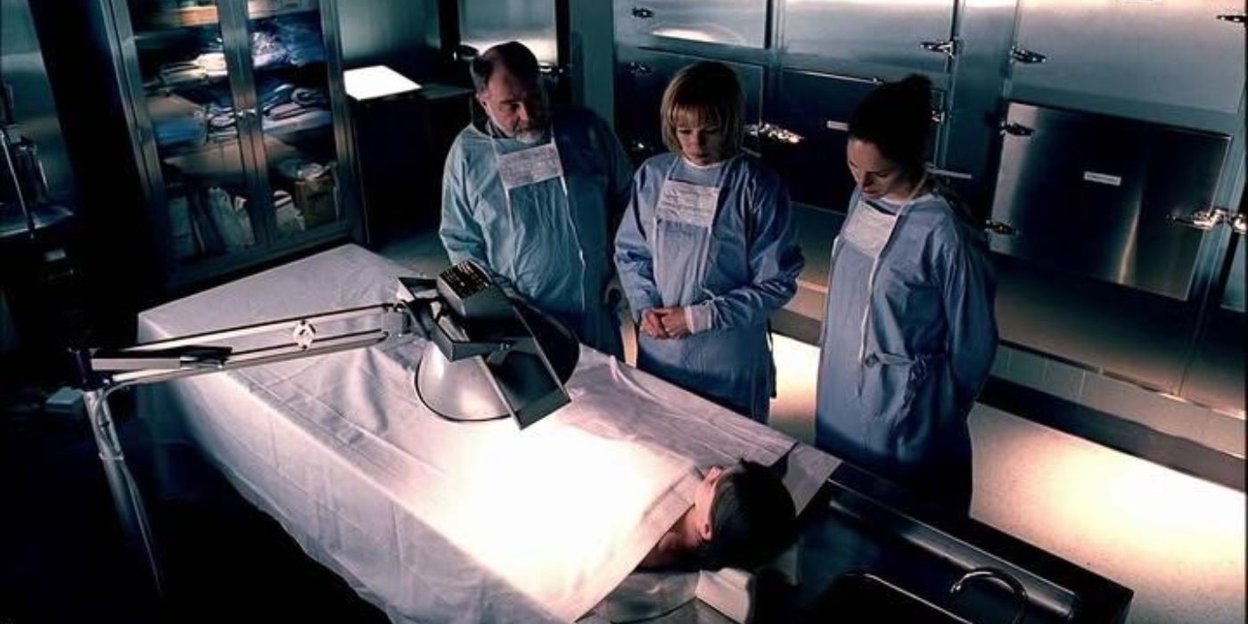 Al Robbins, Catherine Willows, and Sara Sidle looking at a dead body in CSI.