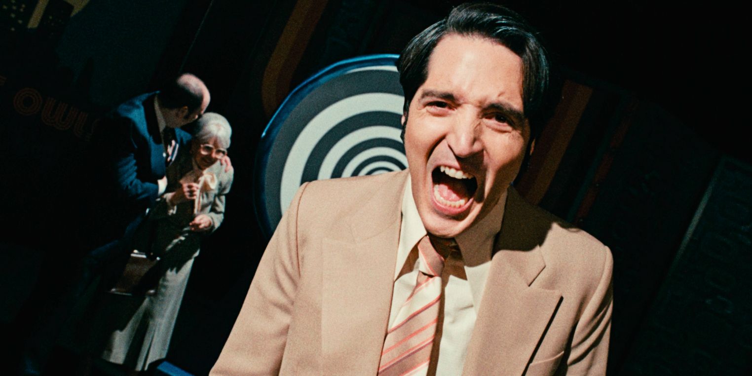 David Dastmalchian screaming with two people and a spiral behind him in Late Night with the Devil
