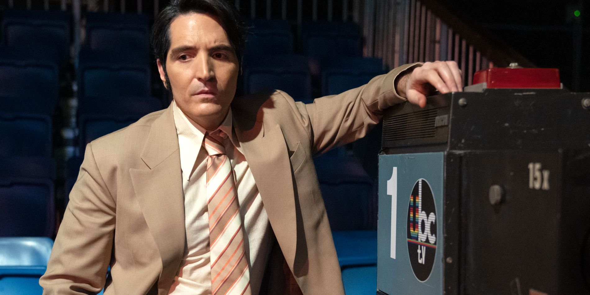David Dastmalchian as Jack Delroy calmly leaning on a TV camera in Late Night with the Devil