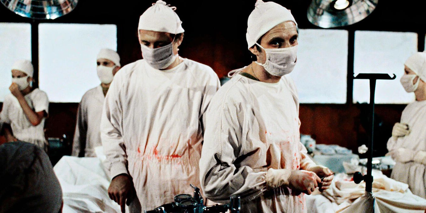 David Ogden Stiers as Charles and Alan Alda as Hawkeye in the operating room in MASH