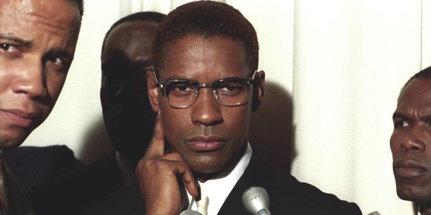 Denzel Washington as Malcolm X is surrounded by reporters of Nation of Islam members in Malcolm X.