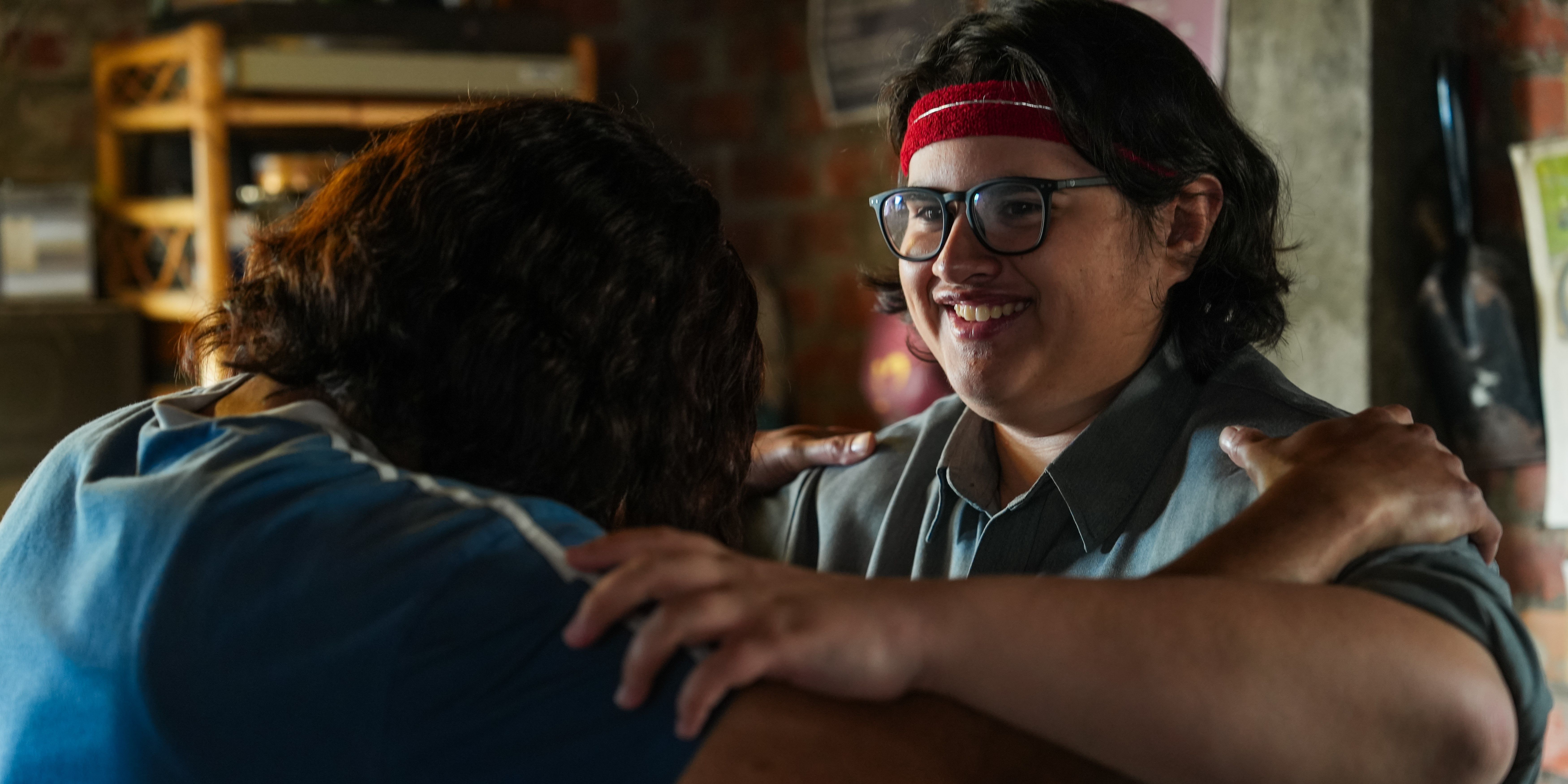 Julian Dennison as Josh Waaka smiling as he holds onto the shoulder of his brother James Rolleston as Jamie Waaka Stills - COURTESY OF BLUE FOX ENTERTAINMENT
