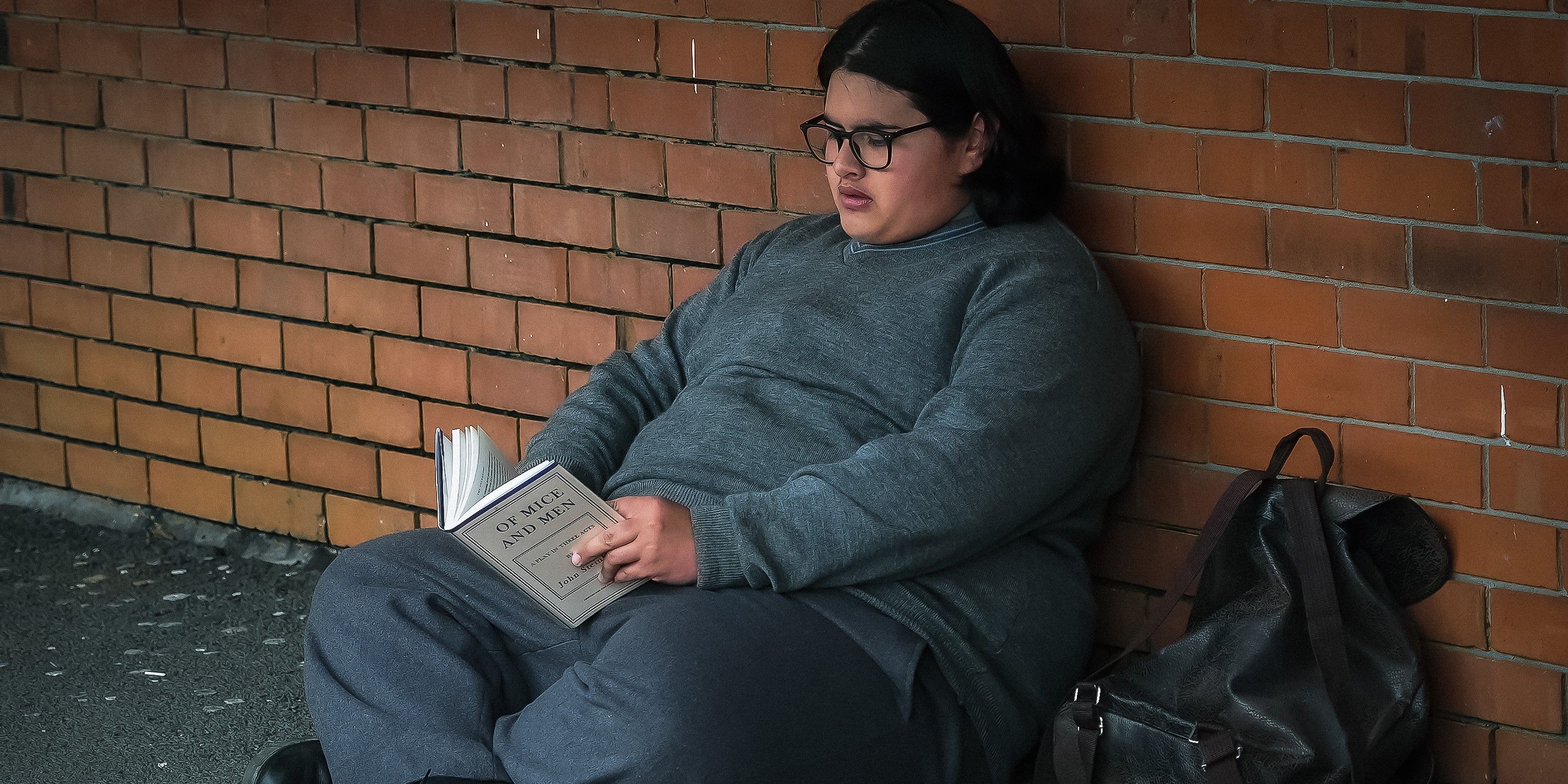 Julian Dennison as Josh Waaka reading a book and sitting down in Uproar (2023) Stills - COURTESY OF BLUE FOX ENTERTAINMENT