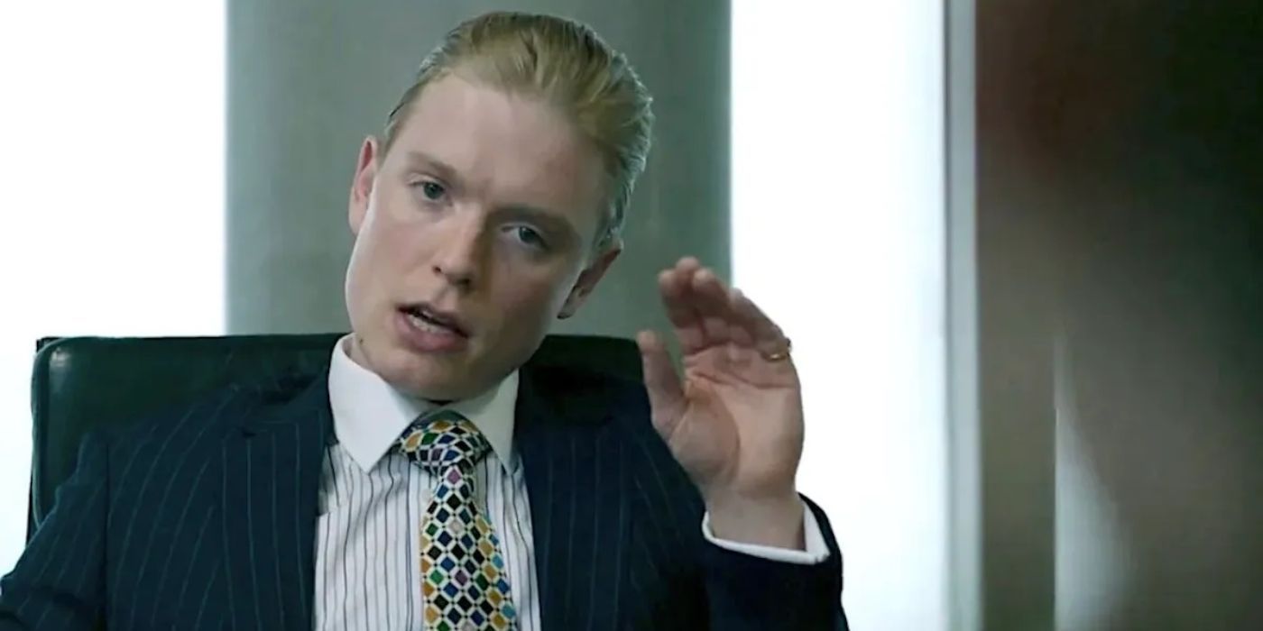 Freddie Fox as James Webb raises his hand and speaks in Slow Horses.