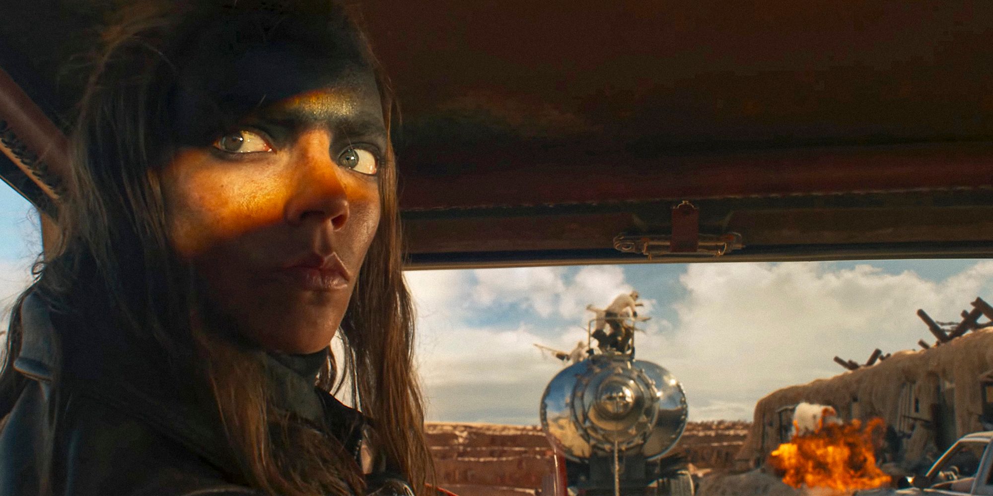 Furiosa in a car looking behind in Furiosa: A Mad Max Saga