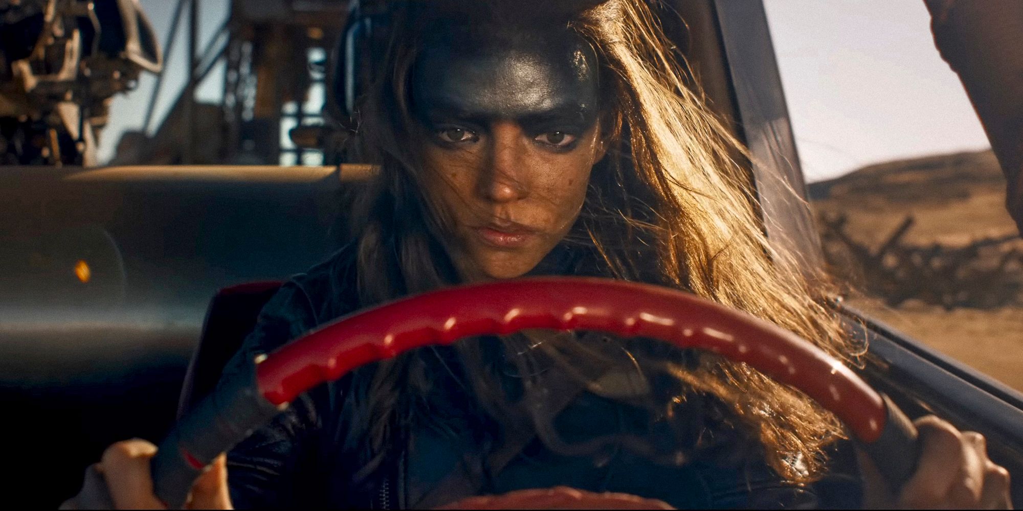 Furiosa driving looking worried in Furiosa: A Mad Max Saga