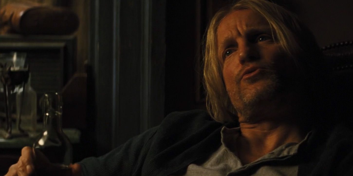 Haymitch segurando uma garrafa de álcool em Jogos Vorazes
