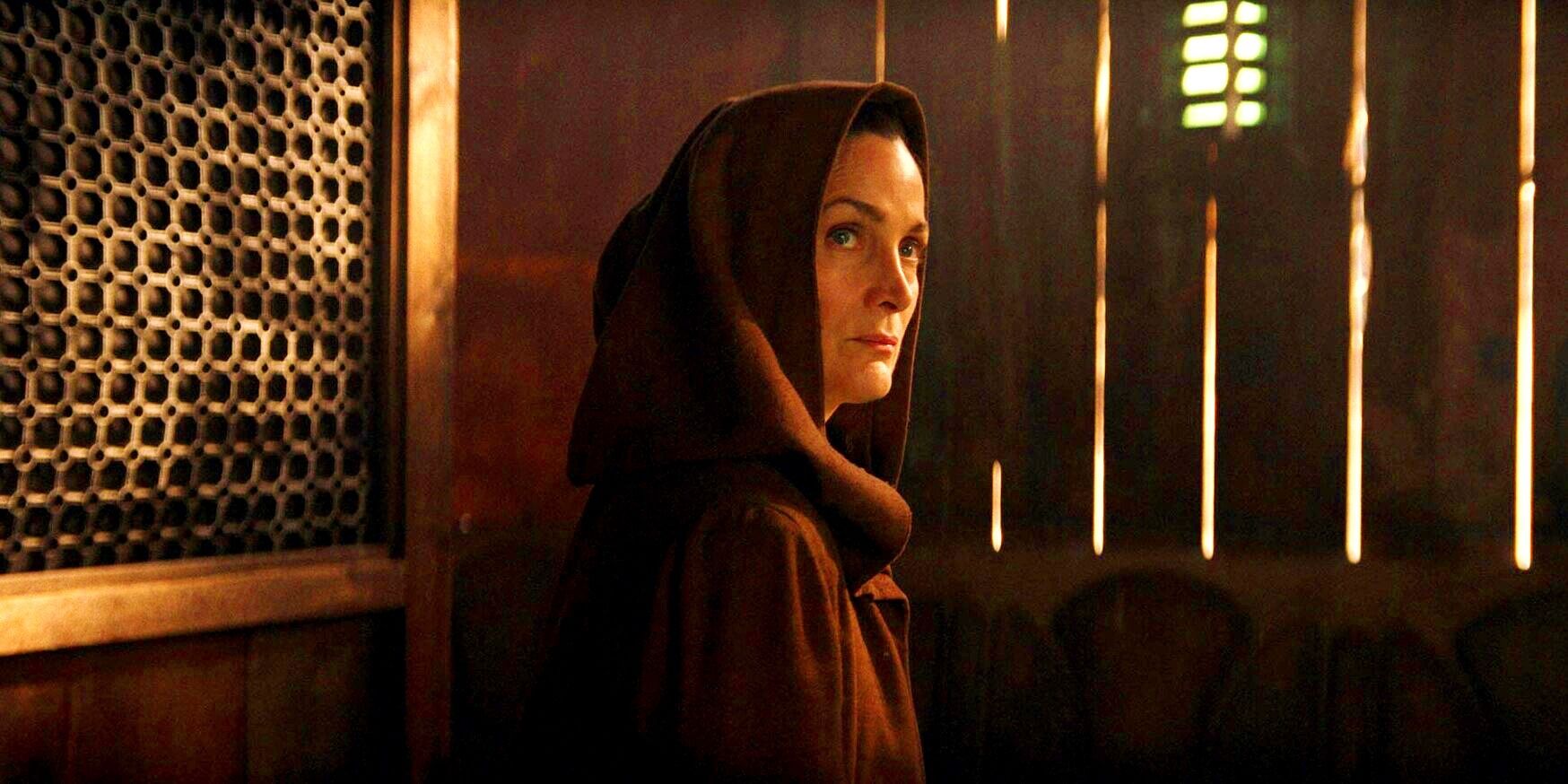 Carrie-Anne Moss as Jedi Master Indara looking out from under her hood in The Acolyte trailer 