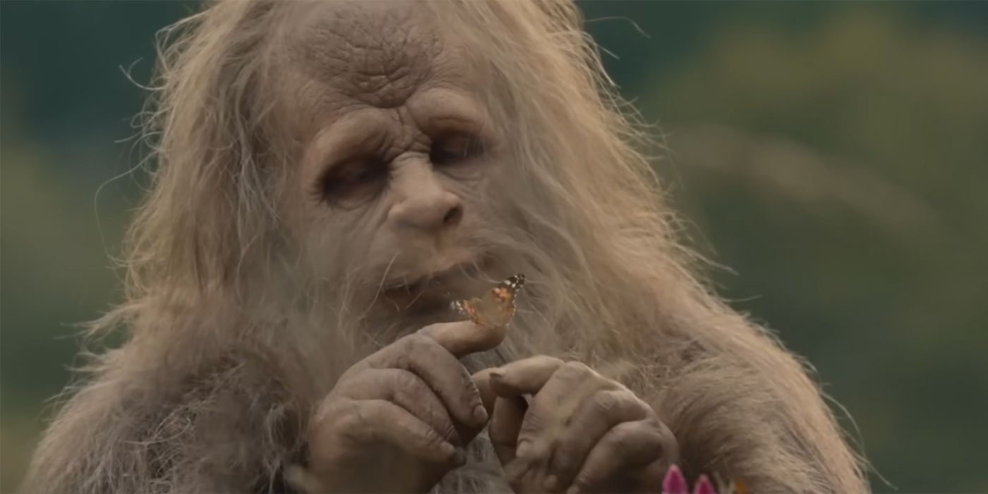 Jesse Eisenberg as a sasquatch holding a butterfly in Sasquatch Sunset