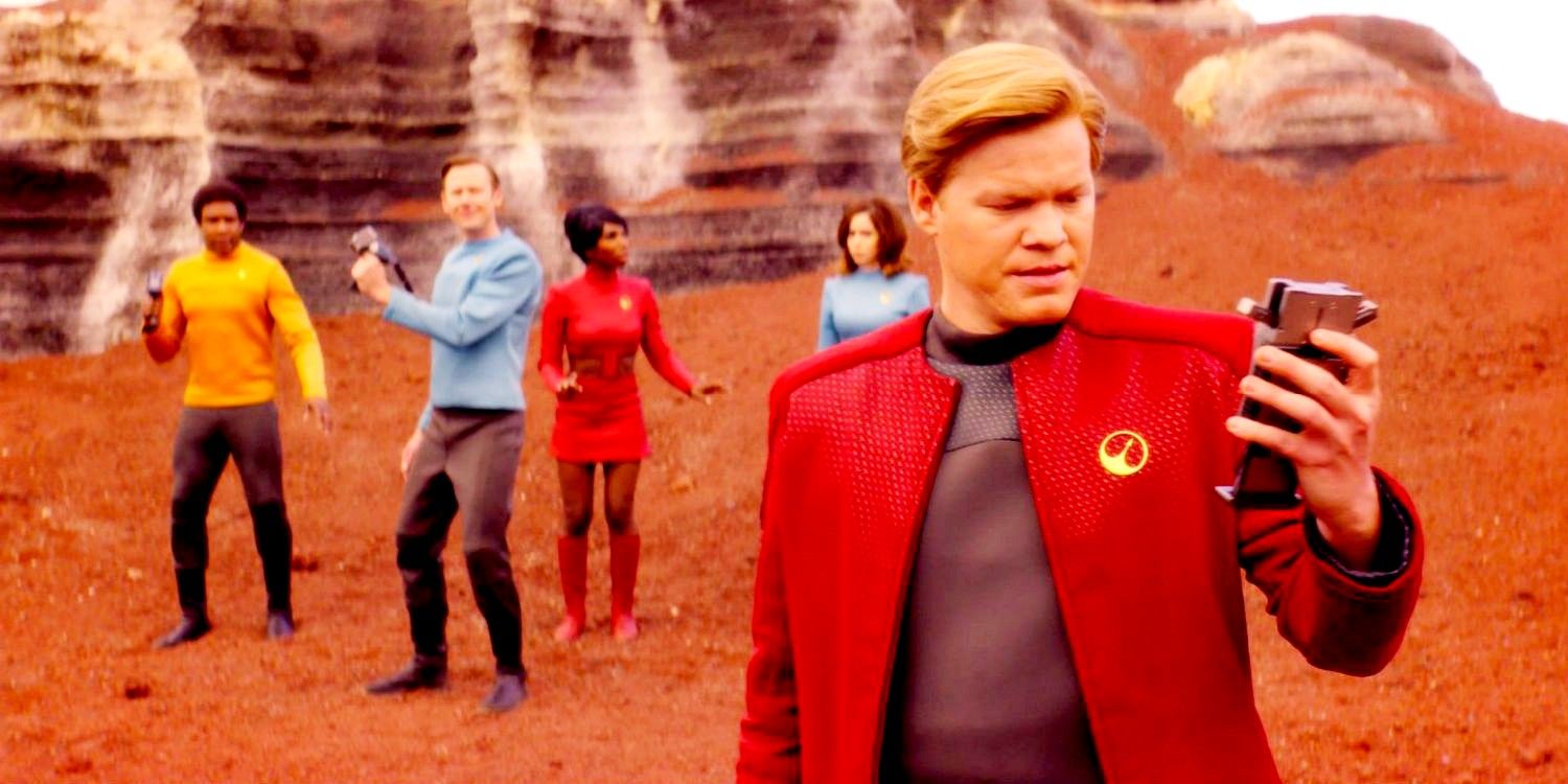 Jesse Plemons as Robert Daly looking at his pad while his team is behind him in Black Mirror USS Callister