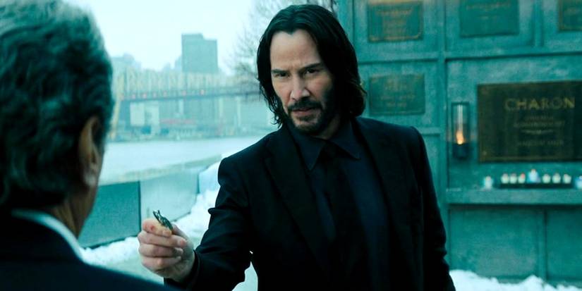 Keanu Reeves Baba Yaga hands over something to Winston in John Wick 4