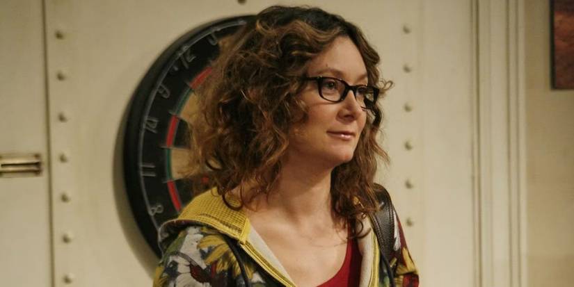 Sara Gilbert as Leslie Winkle standing in front of a door in The Big Bang Theory 
