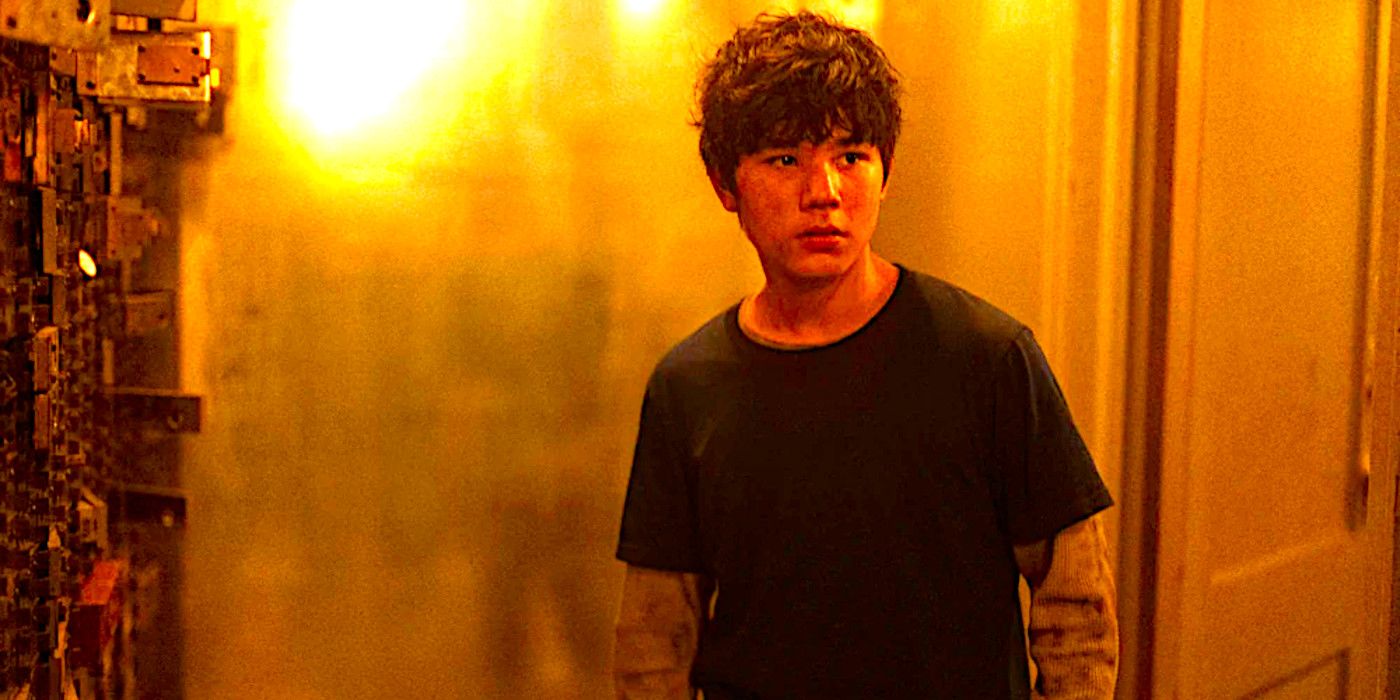 Logan Kim as Hershel stands in a dimly lit hallway in a scene from The Walking Dead Dead City