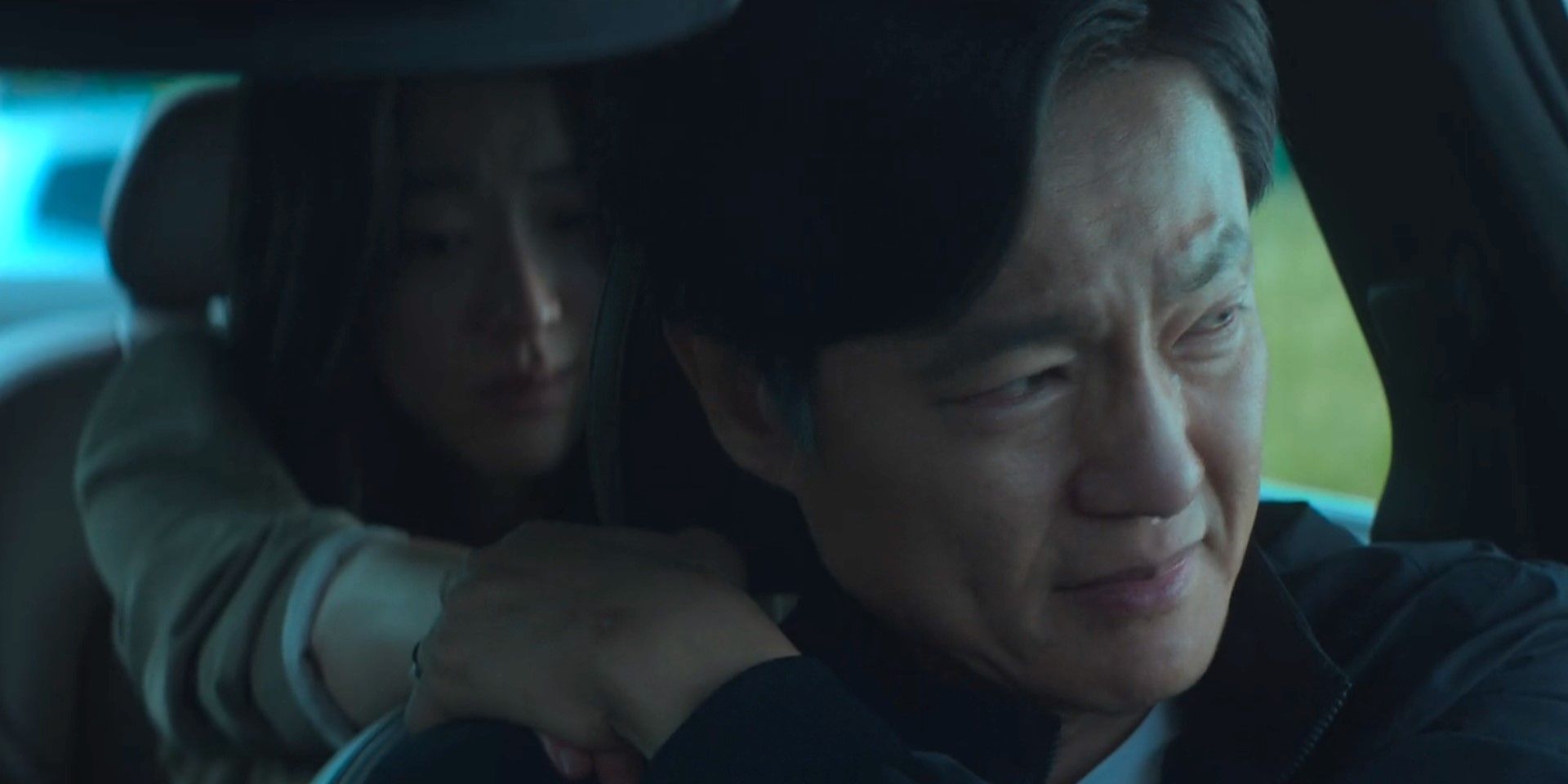 Lee Marie (Choi Sung-eun) hugs Lee Youn-sung (Cho Han-cheul) from the back seat of the car, with both characters crying in My Name is Loh Kiwan