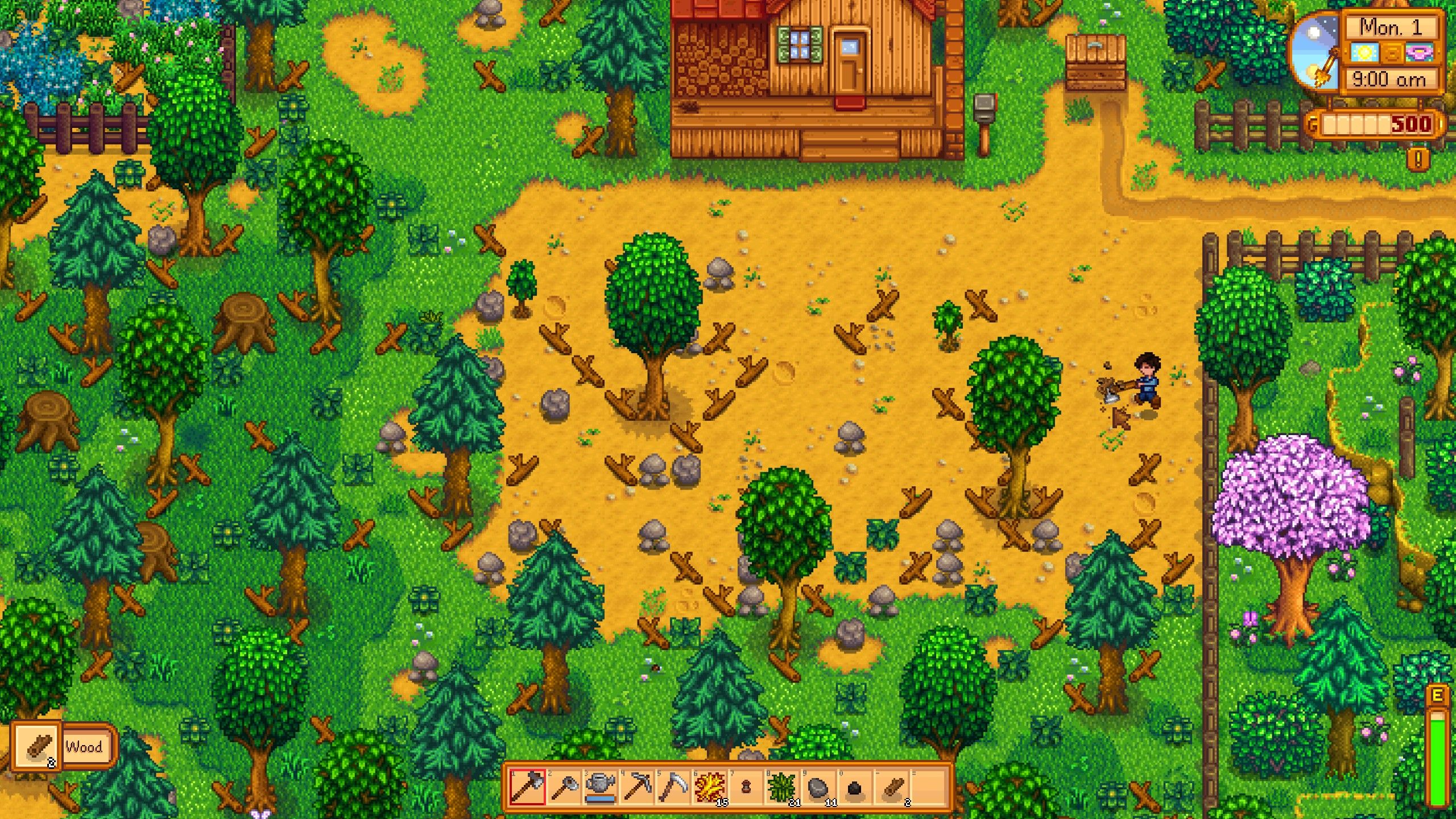 Jogador masculino com camisa azul quebrando madeira na fazenda Stardew Valley Meadowlands