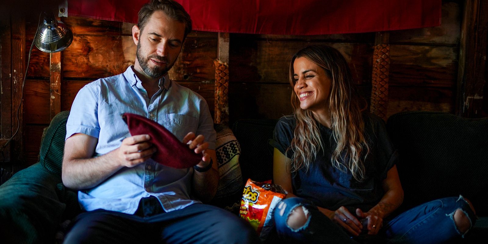 Natalie Morales sitting on couch with Kyle Hausmann-Stokes on set of My Dead Friend Zoe