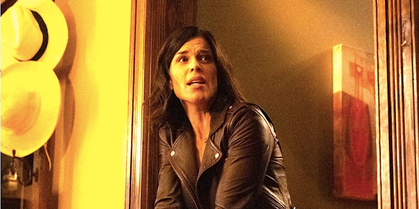 Sidney Prescott de Neve Campbell em uma porta empunhando uma arma em Scream 2022.