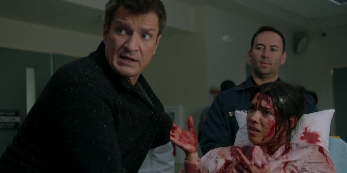 Nolan (Nathan Fillion) and a bloody Bailey (Jenna Dewan) looking scared in The Rookie