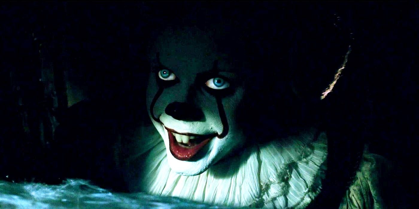 Pennywise de Bill Skarsgård sorrindo nas sombras do ralo no filme de terror de 2017 It