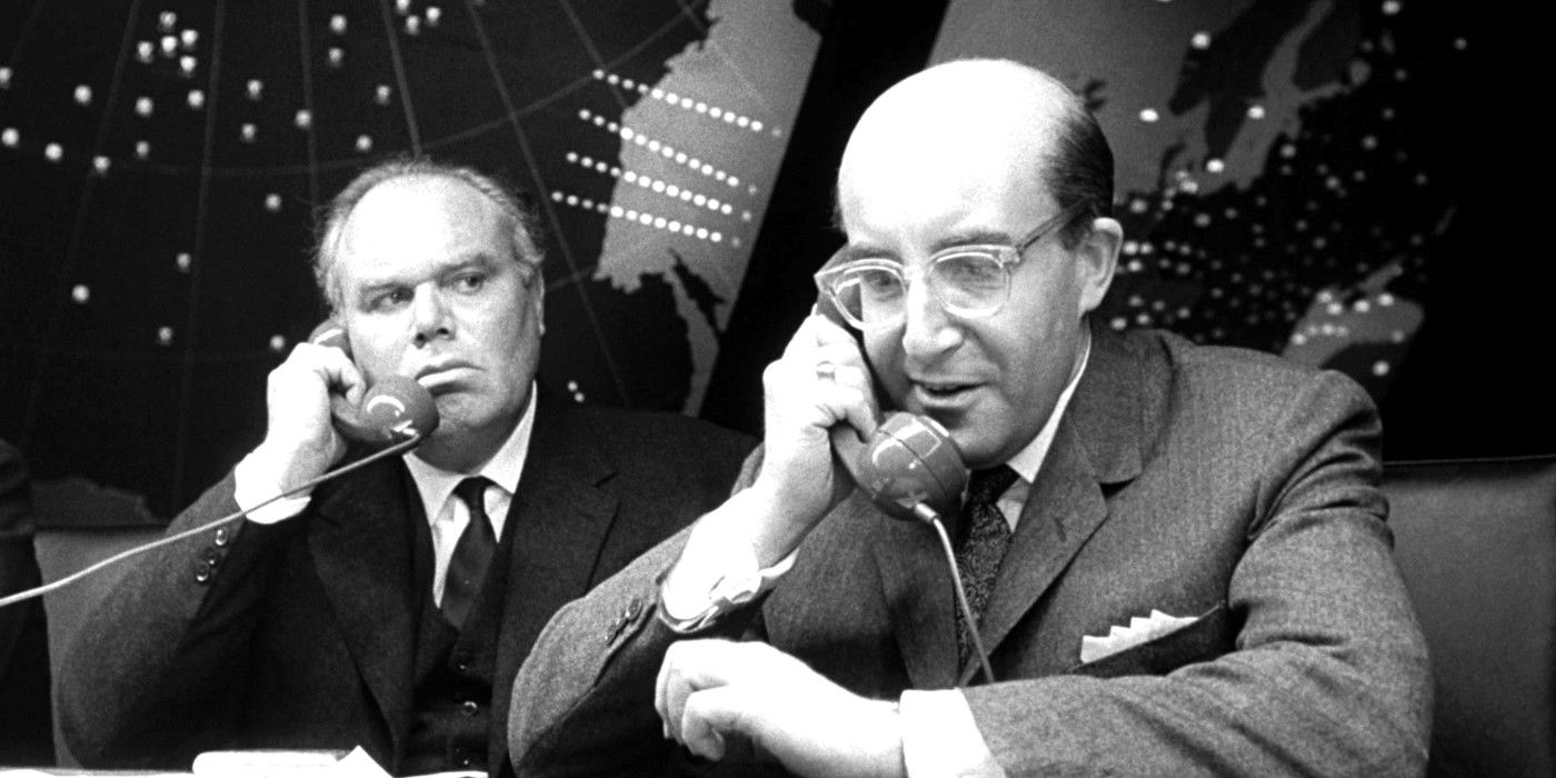 Peter Sellers talks on the phone while Peter Bull listens in in a scene from Dr. Strangelove