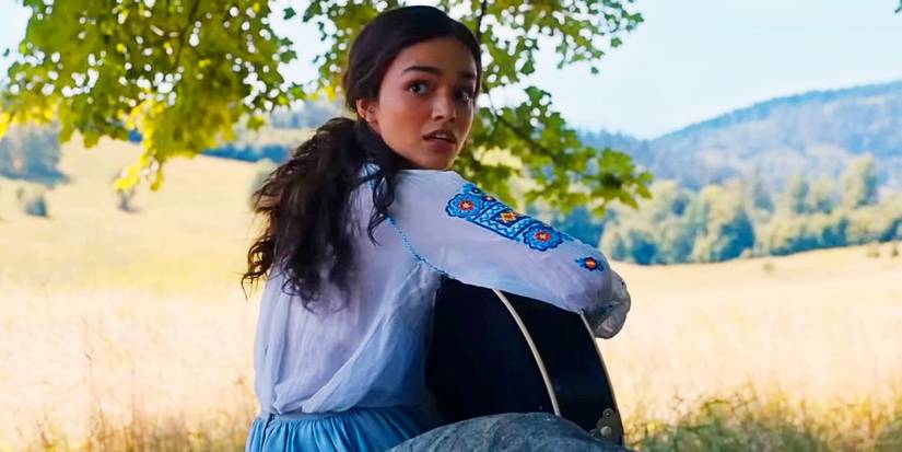 Rachel Zegler as Lucy Gray Baird Turning While Playing the Guitar in The Hunger Games The Ballad of Songbirds and Snakes