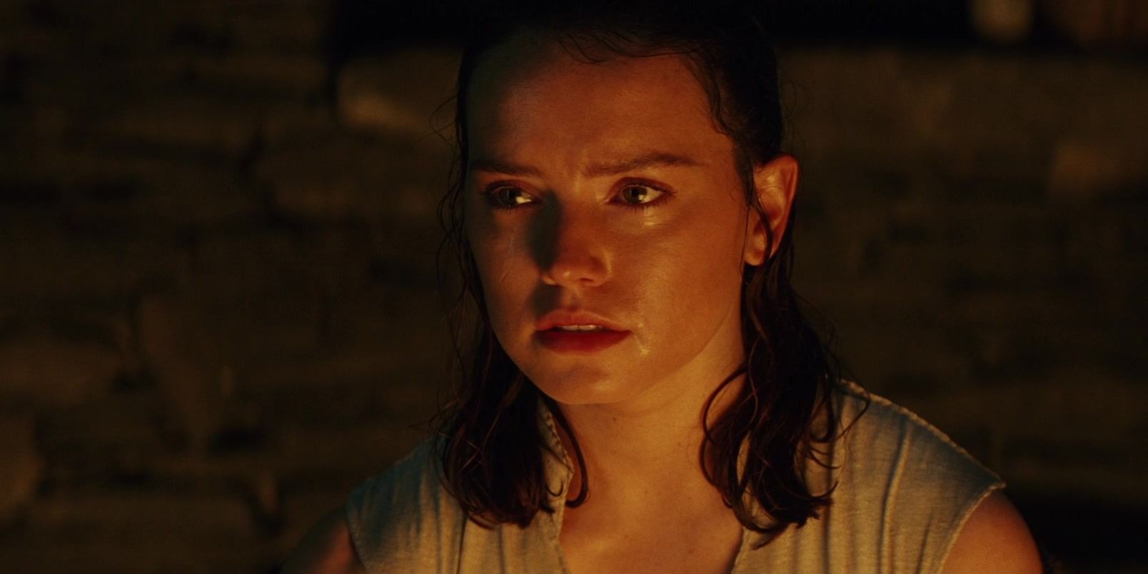Rey looking upset with tears in her eyes in The Last Jedi