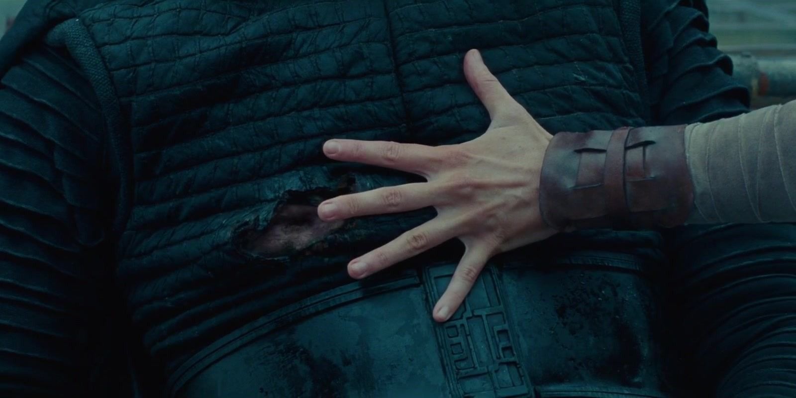 Rey holding her hand over Kylo Ren's wound to heal it