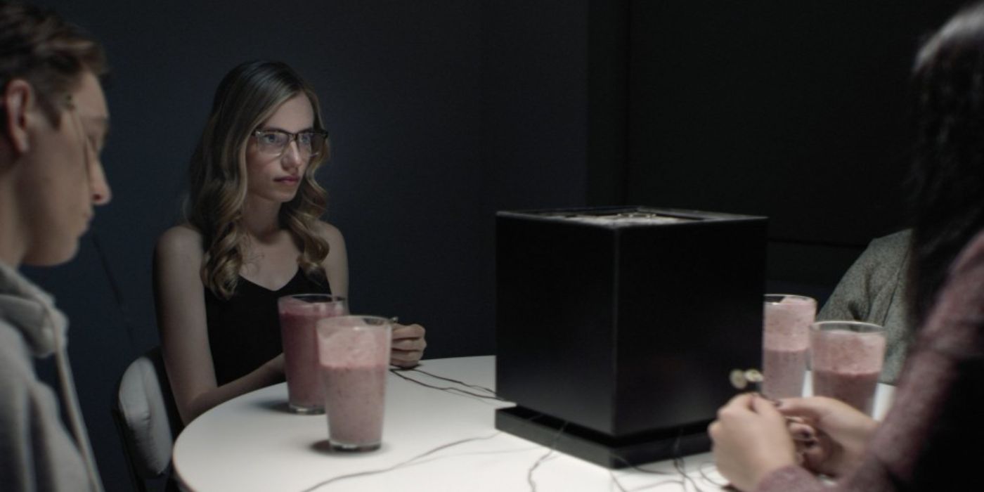 Samantha (Anja Savcic) at a table with three other people sitting around a black box with wires coming out of it in Incontrol. - Anja Savcic Plays Samantha - Incontrol (2017)
